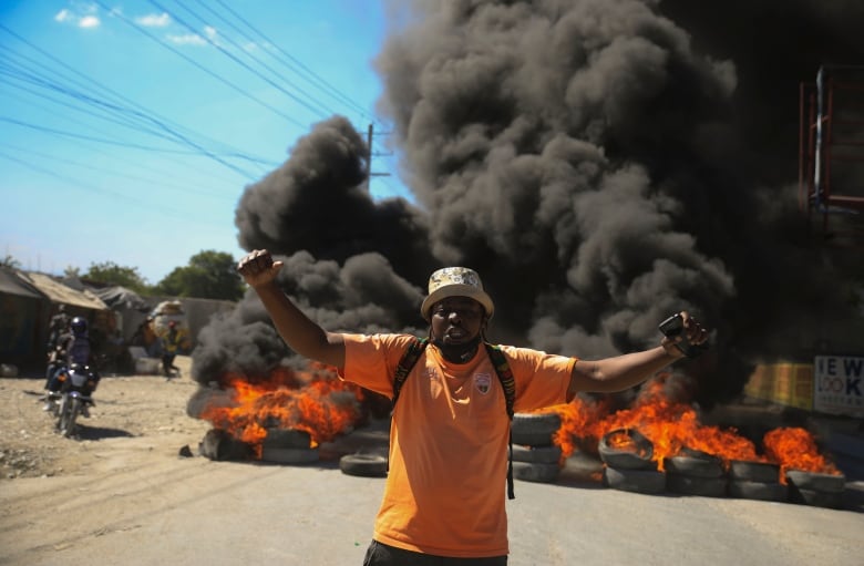 A protester shouts anti-government slogans by a burning barricade set up by members of the police to protest bad police governance in Port-au-Prince, Haiti on Jan. 26, 2023. A wave of grisly killings of police officers by gangs has spurred outrage among Haitians.