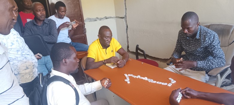 Striking teachers taking a party of Domino inside the Ministry of Education’s office in Port-de-Paix, which they have occupied since April 21. Photo by Kervenson Martial/The Haitian Times.