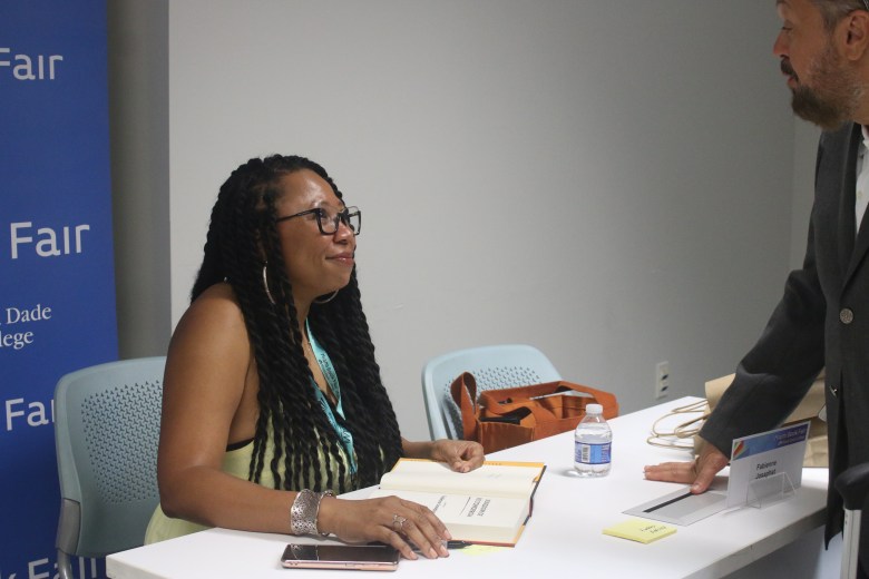 Haitian-American writer Fabienne Josaphat signs a copy of her second novel, Kingdom of No Tomorrow, after taking part in a panel discussion at Miami Dade College during the Miami Book Fair on Sunday, Nov. 23, 2025. Photo by Béatrice Vallières for The Haitian Times.
