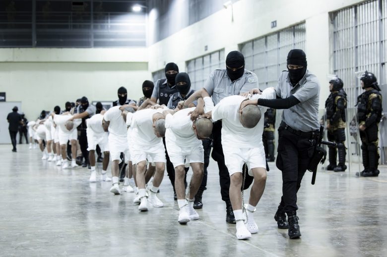 Prisoners are escorted by guards at the mega prison known as Detention Center Against Terrorism (CECOT) in Tecololuca, El Salvador. (Presidencia de El Salvador via AP)