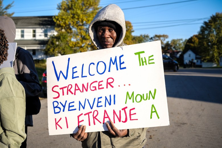 A Haitian marcher holds a placard during the 40-mile procession in Springfield, Ohio, on Wednesday, October 21, 2026.  
